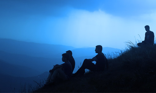 3 men looking out at the scenery on a blue night