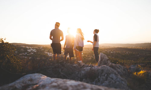 4 Gente de pie sobre una roca mirando hacia el horizonte
