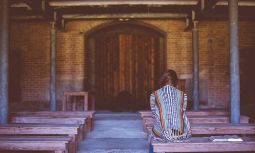 Woman praying alone in a church