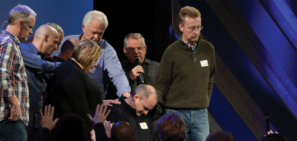 Pastors laying hands and praying for church planter