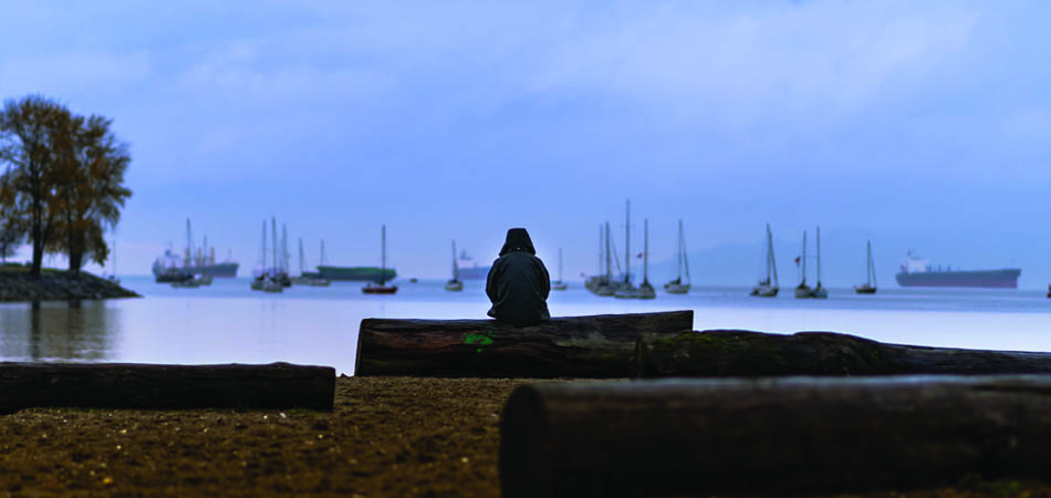 Woman sitting alone on beach