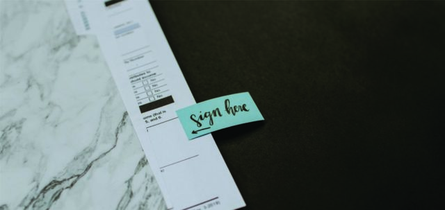 Legal Document with Sign Here Sticker
